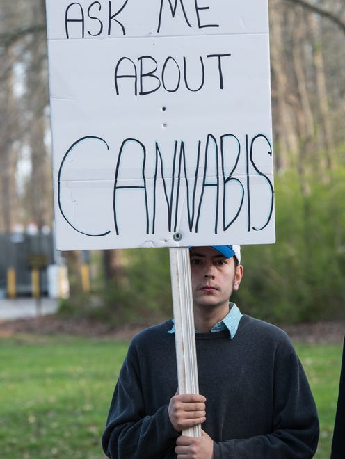 Tim Duck, of Salisbury, holds a sign during a protest at Maryland State Police Barrack V in Berlin on Wednesday, April 11, 2018.