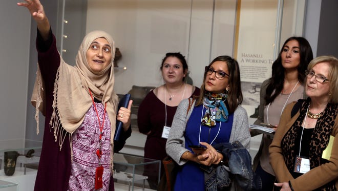 In this April 26, 2018 photo, Moumena Saradar, left, originally from Syria, guides visitors through the Middle East gallery at Penn Museum, in Philadelphia. The University of Pennsylvania Museum of Archaeology and Anthropology is in the midst of dramatic renovations, opening new galleries to showcase previously undisplayed items, telling the stories of those artifacts in more relatable ways and adding guides native to the parts of the world being showcased.