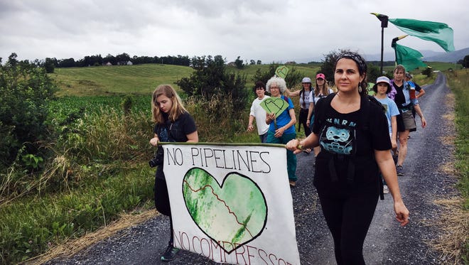 Activists walking in opposition to the Atlantic Coast Pipeline as part of "Walking the Line," an event that has the group hiking along the pipeline's proposed route, make their way down Jennings Gap Road in Churchville, Va., on Friday, June 23, 2017.