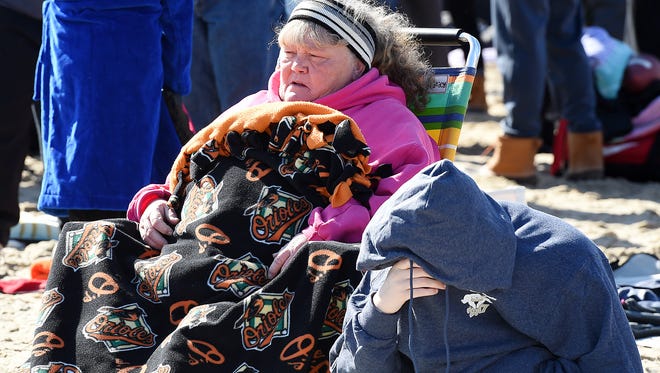 Well-wishers wrapped themselves in blankets while watching the polar bears hit the water during Sunday's Polar Bear Plunge on Rehoboth Beach.