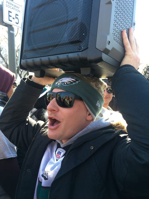 Nick Lutz, a 25-year-old who lives in Fishtown, alternated between holding the speaker above his head and standing on it as a platform to better see the parade.