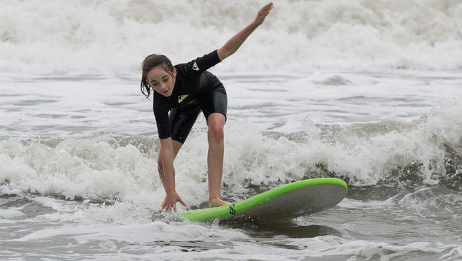 Madison Pusey rides a wave in Ocean City on Sunday, Oct. 15, 2017.
