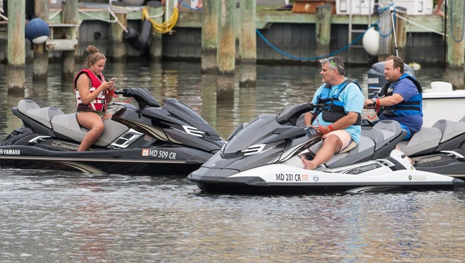 Spectators on jet skis await the arrival of incoming boats during the final day of the White Marlin Open on Friday, Aug. 11, 2017.