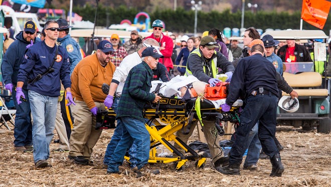 Paramedics take an injured person to an ambulance after a piece of metal flew off of an air cannon, striking them in the head, at the World Championship Punkin Chunkin in Bridgeville on Sunday afternoon.