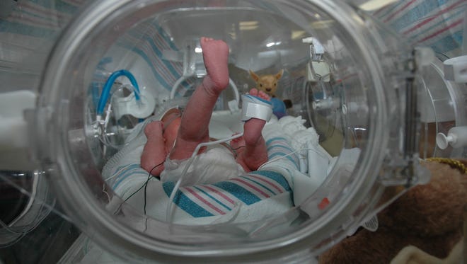 An infant in an incubator.