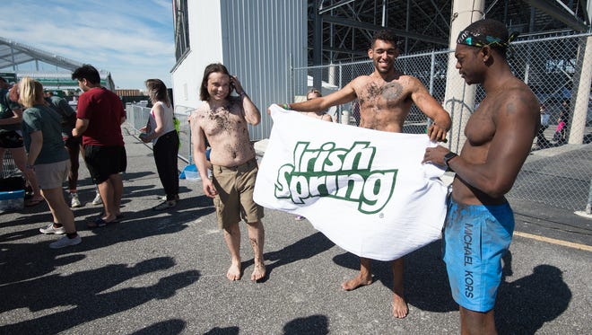 Mark Niederberger, left, of Philadelphia, Pa., Erick Cisnado of Silver Spring, Md., and Shaquille Matadi of Silver Spring, Md., preparing to participate in the Irish Spring attempt to break the Guinness World Records of the most people showering simultaneously at the Firefly Music Festival in Dover.