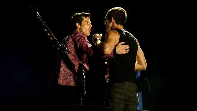 The Killers singer Brandon Flowers greets West Chester's Brian Bagosy on stage at Firefly Music Festival in Dover Saturday.