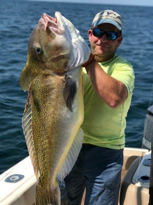 Tom Schanno, of Halethorpe, Md., holds up his Delaware record golden tilefish. The fish weighed more than 46 pounds.
