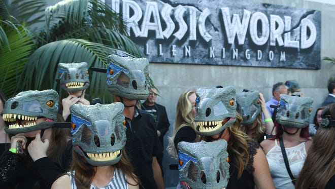 Fans wearing dinosaur masks greeted the stars as they arrived on the red carpet.