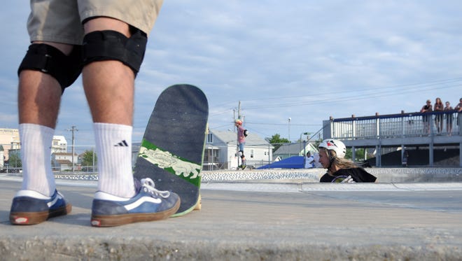 Zach Coch, 13 of Berlin, swirls around the bowls as others watch in Ocean City at the Ocean Bowl Skate Park.