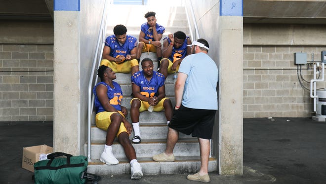 Blue teammates take a break on the steps of Delaware Stadium. Members of the Blue-Gold football All-Stars participate in media day Sunday at Delaware Stadium in Newark.