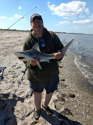 Michael Radigan holds a shark that he caught at South Bowers Beach on cut bunker.