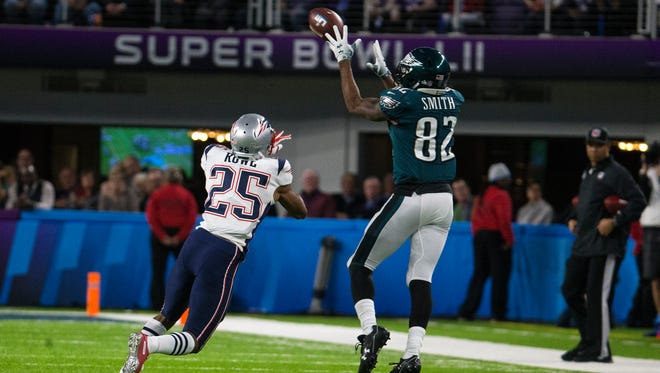 Eagles' Torrey Smith makes a reception despite the efforts of New England's Eric Rowe Sunday at US Bank Stadium.