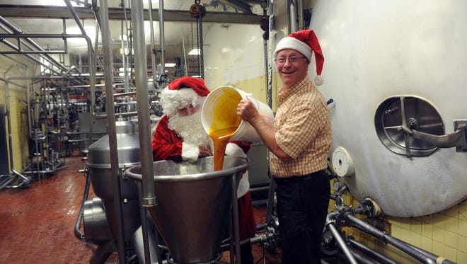 Lewes Dairy President Chip Brittingham, with some help from Santa, working on the Christmas in July eggnog batch.