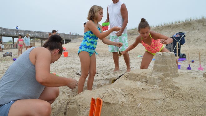 Carmen Corkle, Aliyah Signor, 10, Clayton Cobaugh and Jasmin Corkle , 8, work to build an elaborate castle complete with a moat and drawbridge at the Delaware Seashore State Park Sandcastle Contest in 2016.