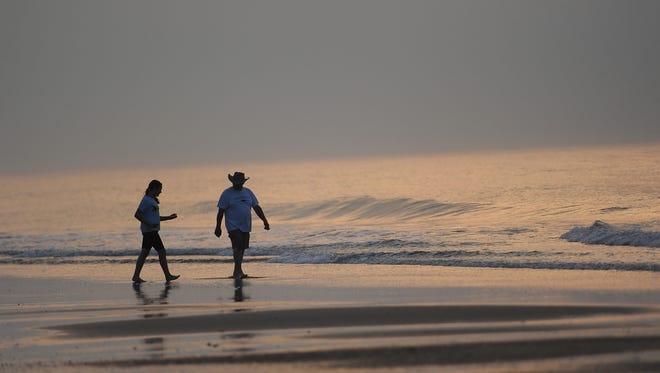Don Seeterlin and his niece Makenzie Mills walk in the surf at Assateague beach as they wait for Saltwater Cowboys to lead the northern herd of Chincoteague Ponies to their corral on Monday morning, July 25, 2016. The 91st Annual Chincoteague Pony Swim is Wednesday.