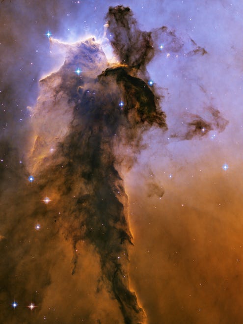 This image made by the NASA/ESA Hubble Space Telescope shows a tower of cold gas and dust rising from a stellar nursery called the Eagle Nebula. The soaring tower is 9.5 light-years high, about twice the distance from our Sun to the next nearest star.  The Hubble Space Telescope marks its 25th anniversary. A full decade in the making, Hubble rocketed into orbit on April 24, 1990, aboard space shuttle Discovery. (NASA, ESA, Hubble Heritage Team STScI/AURA via AP) ORG XMIT: NY927