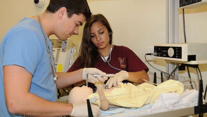 Students practice a procedure on an infant mannequin at Henson Medical Stimulation Center at Salisbury University.
