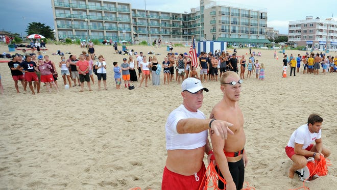 Rehoboth Beach Patrol Captain Kent Buckson talks strategy with Andrew Brady at the start of the landline as as the 39th Annual Lifeguard Olympics were held under threatening skies on Thursday, July 28 on the beach at Baltimore Avenue in Rehoboth Beach with Beach Patrols from Rehoboth, Dewey, Bethany, South Bethany, Middlesex, Fenwick Island, Delaware State Parks and Ocean City.