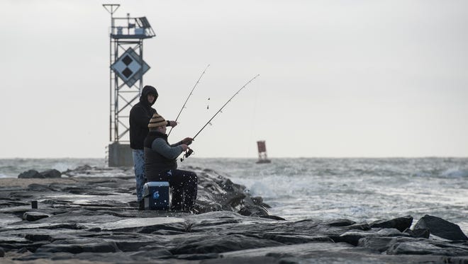 Stanislav Belash, left, of Berlin, and Max Oganyan, of Whaleyville, fish along the Ocean City Inlet jetty during the King Tide on Sunday, Nov. 5, 2017.