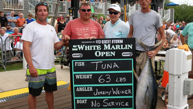 Crew members of the boat No Service pose for a photo with their tuna at the White Marlin Open on Monday, Aug 8, 2016.