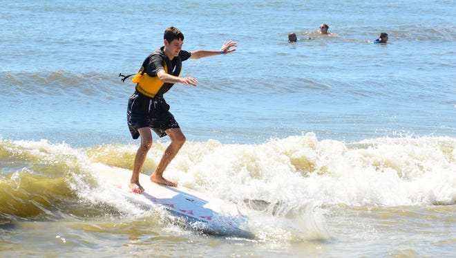Michael Mulch, 15, Eldersburgh, Md. catches a wave during the Surfers healing tour that helps people living with autism by exposing them to a surfing experience in Ocean City. on August 17, 2016.