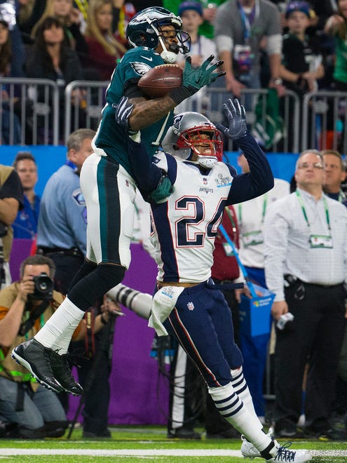 Eagles' Alshon Jeffrey jungles a pass that would go on to be intercepted while under pressure from New England's Stephon Gilmore Sunday at US Bank Stadium.