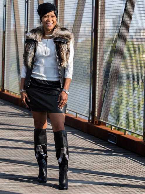 Doranna Clemment wears a black faux leather mini skirt with black faux leather zip-vest trimmed in fur, both from Marshalls; over-the-knee leather patch boots by Aldo.