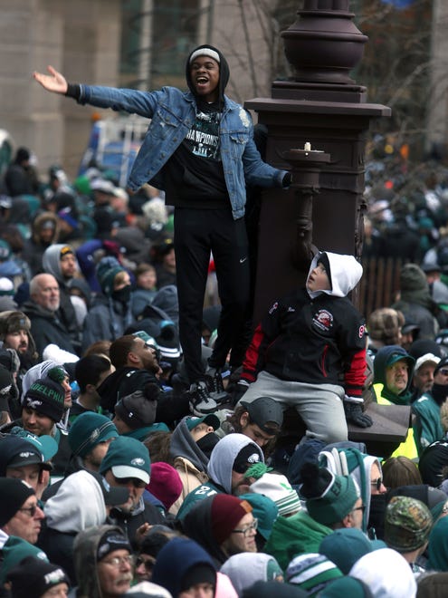 A Philadelphia Eagles fan cheers after climbing a light pole during the Eagles team parade and celebration Thursday Feb. 8, 2018, in Philadelphia. The Eagles defeated the New England Patriots in Super Bowl 52.