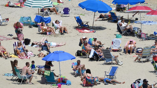 Cool weather keeps visitors out of the water in Rehoboth Beach as the Memorial Day weekend starts the summer season with a large crowd on the beach and boardwalk on Sunday, May 28, 2017.
