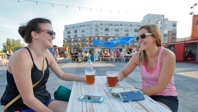 Leslie McGowan (left) and Annette DeBastiani, both of Wilmington, share a table as they hang out following a yoga class at Constitution Yards beer garden at the Wilmington Riverfront.