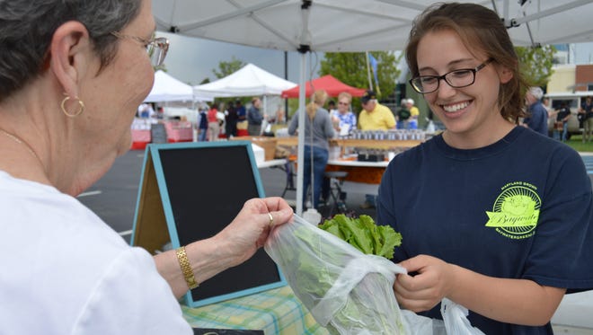 Jess Molnar, 22, sells fresh lettuce from Bay Water Greens at the Milton's Farmers' Market April 22.