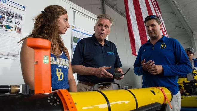 Sophie Phillips, a University of Delaware Marine senior, and  professor Art Trembanis demonstrate the operation of an autonomous underwater vehicle to Virginia Gov. Terry McAuliffe at Wallops Flight Facility on Friday, Sept. 22, 2017.