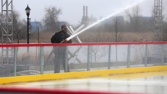 Tex Varney, a production manager for New Castle-based Light Action Productions, sprays water onto the Riverfront Rink in Wilmington earlier this week.