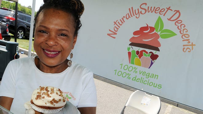 Owner Sherimane Johnson of Naturally Sweet Desserts from Philadelphia holds a vegan cupcake.