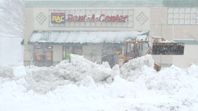 Construction equipment trying to clear the parking lot of Rent-A-Center in Milford Saturday.
