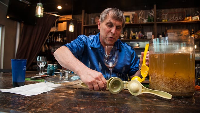 David Engel trades out an old lemon squeezer for a new one before sieving the ginger out of the vodka infusion. The ginger is featured in one of the many specialty drinks available at a(Muse.) in Rehoboth.