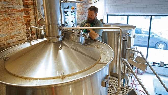 Andrew Rutherford, head brewer at Stitch House Brewery, cleans a brewing tank at the new brewery opening soon on North Market Street.