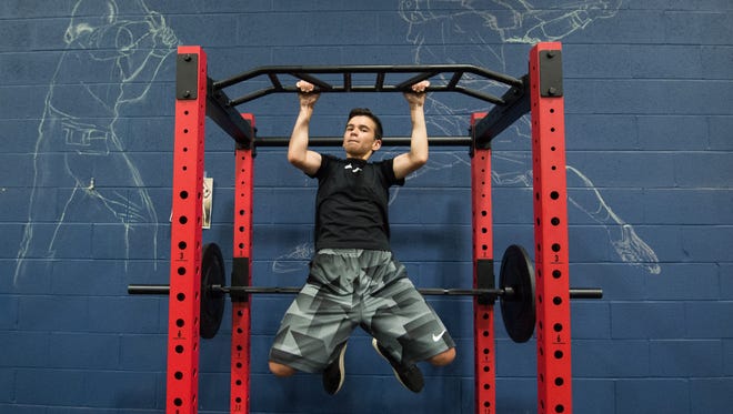 Jacob Simpson (13) does pull-ups during a training session with Sports Specific Training at Slim's Sport Complex in Middletown.