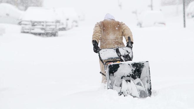 Mike Murray of Hockessin, Del. drags his snow blower through 18 inches of snow around the corner to his neighbors house who has a back problem to help him dig out of the heavy snow storm which hit the state and Gov. Jack Markell declares a state of emergency.