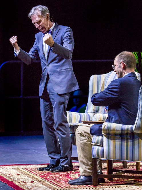 Bill Nye reacts to cheers from the crowd as he takes the stage for a moderated discussion with University of Delaware professor McKay Jenkins (right) at the Bob Carpenter Center in Newark on Tuesday night.
