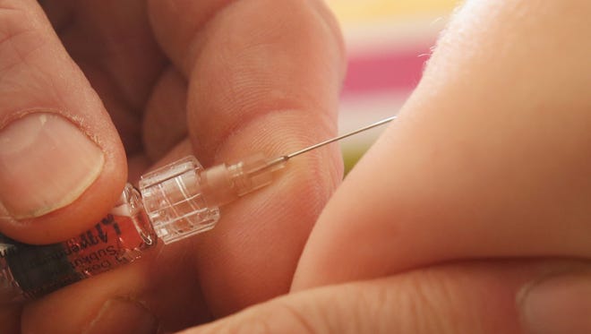 A children's doctor injects a vaccine against measles, rubella, mumps and chickenpox to an infant on Feb. 26, 2015.