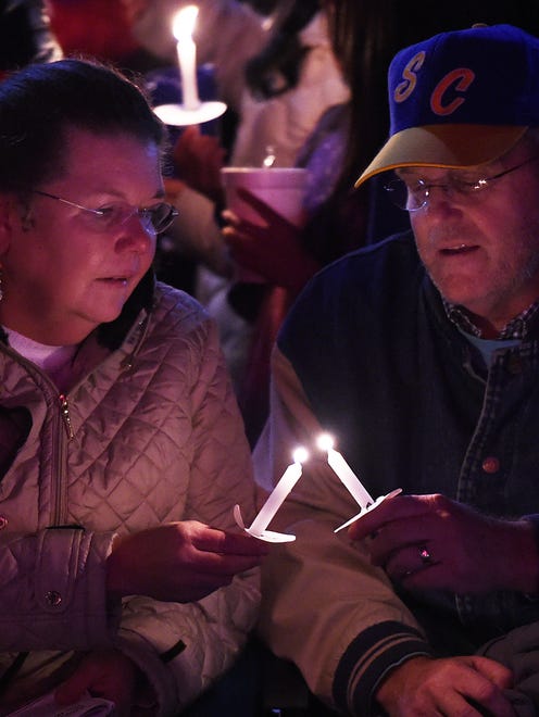 A participants gets help in lighting the candle at the Caroling on the Circle event in Georgetown.