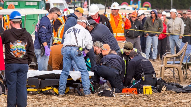 Paramedics tend to an injured person after a piece of metal flew off of an air cannon, striking them in the head, at the World Championship Punkin Chunkin in Bridgeville on Sunday afternoon.