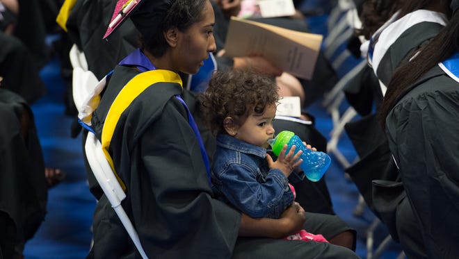 Shadasia Bell of Dover holds her 14 month old daughter Kennedi Echevarria before the start of the Wesley College Spring Commencement in Dover.  A total of 244 graduated.