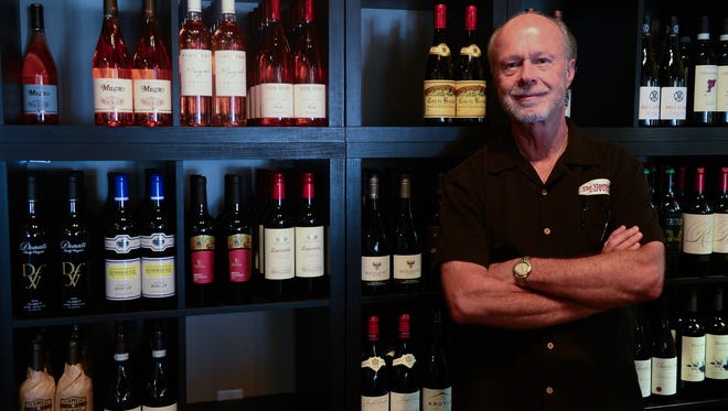 The Vineyard Wine Bar & Bistro Joe Lertch, Owner, stands in front of a portion of the wine selection offered. Tuesday, July 18, 2017.