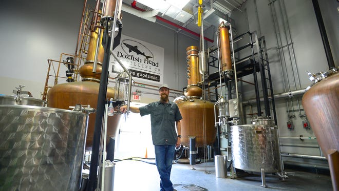 Dogfish Head's lead distiller Graham Hamblett, stands among the brass stills at the Dogfish Head Distillery located in Milton, Del. on Friday, July 14, 2017.