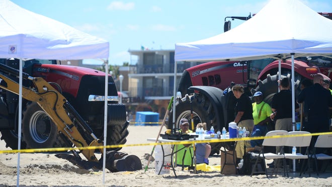 Ocean City Police and Forensics use a backhoe to dig around the area where an unidentified body was found this morning around the 2nd Street beach in Ocean City, Md. on Monday, July 31, 2017.