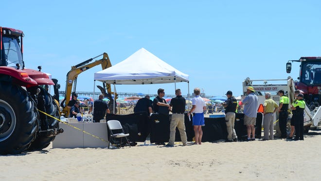 Ocean City Police and Forensics Units use a backhoe to dig around the area where an unidentified body was found this morning around the 2nd Street beach in Ocean City, Md. on Monday, July 31, 2017.