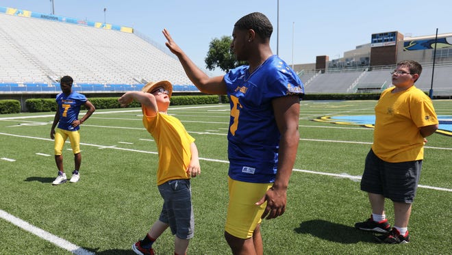 Josh Grieten, left, high fives Hodgon's Vaughn Wood. Members of the Blue-Gold football All-Stars participate in media day Sunday at Delaware Stadium in Newark.